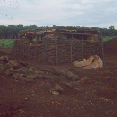 as an exercise in field engineering, this was not a good example..!  Too many bosses led to several design changes & ultimately the sandbags were placed not for protection but to prevent the structure falling down.  An anti-RPG mesh net was later added in front of the bunker for extra protection     [Young]