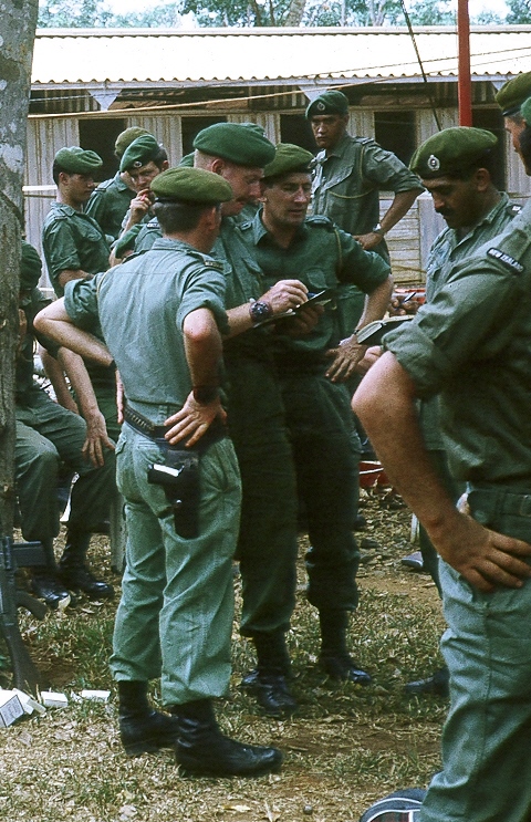 Coy HQ admin 'brains trust' fm left: CQMS Ron Litchwark [pistol], CSM WO2 Doug Mackintosh [notebook], Sgt Dave Heyward [2Pl Sgt], Coy 2ic Capt Jim Brown [diary], Maj Evan Torrance [on right edge] [Stock]