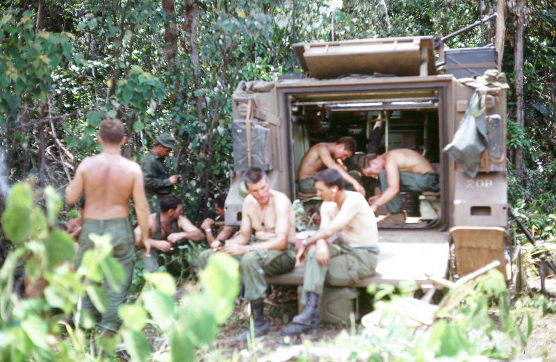 Coy HQ in the field with APC, Maj Torrance with Padre Stac sitting in middle without shirts [Stock]